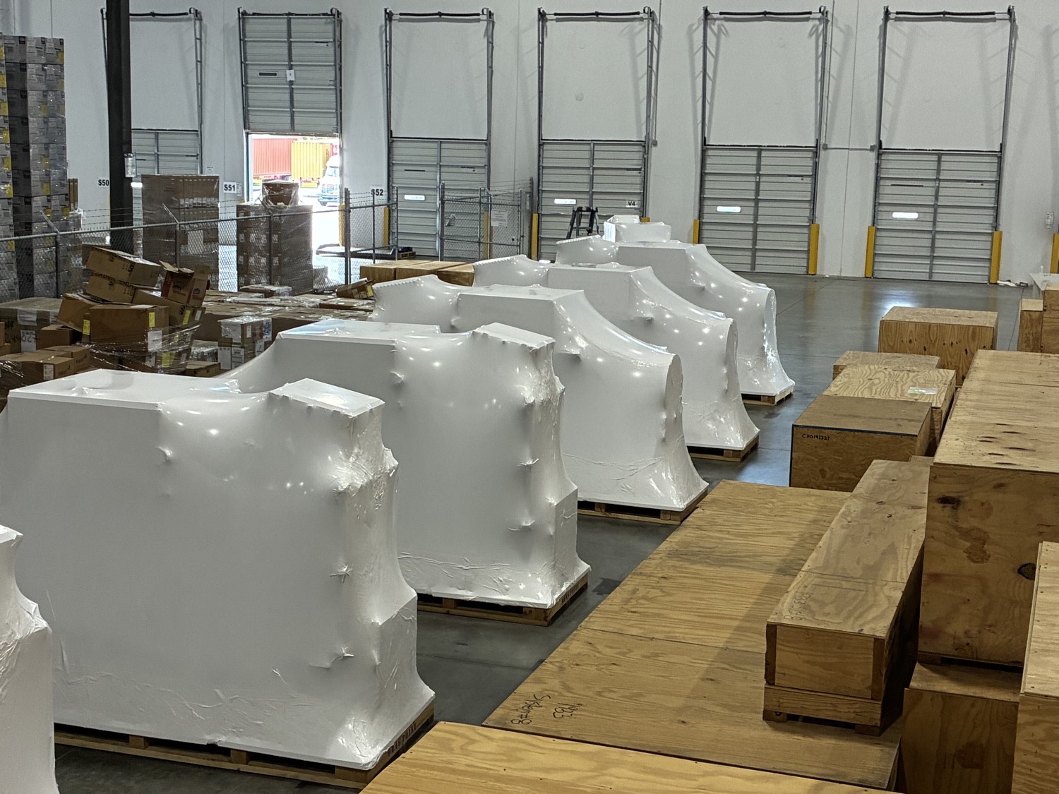 Warehouse row of shrink-wrapped equipment